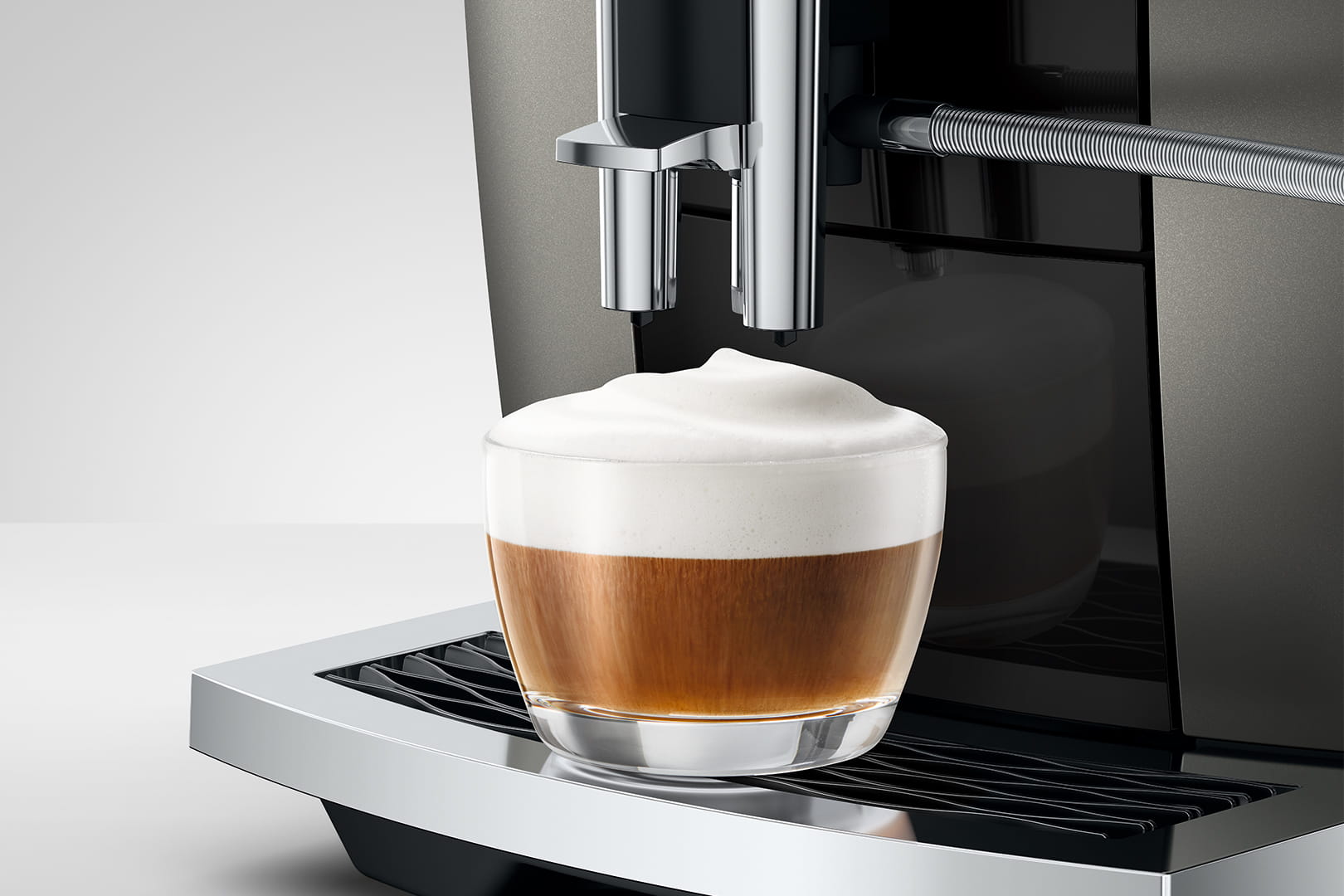 Zbliżenie na wylewkę w E6 ED oraz kawę cappucccino